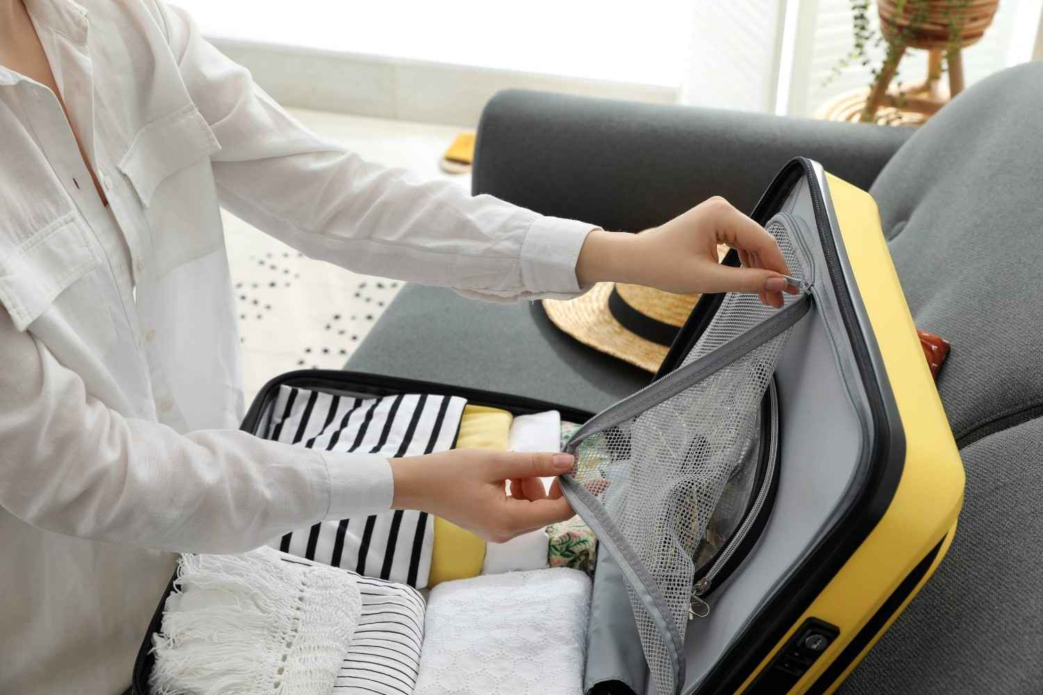 A Woman Packing Clothes In A Luggage
