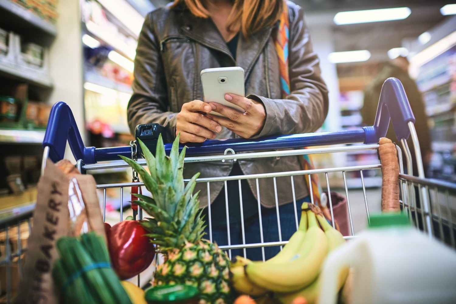 A Woman Using A Phone In A Grocery Store
