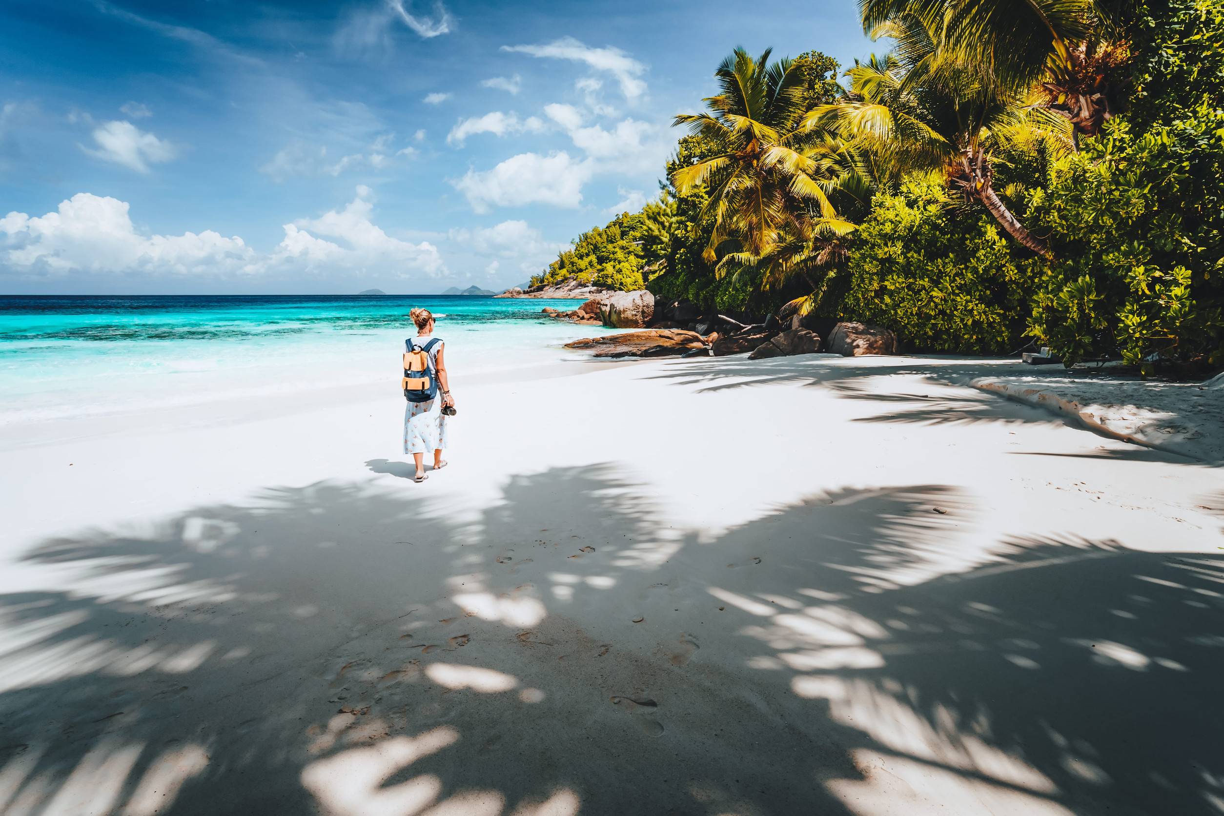 A Woman Walking On A Beach In Mahe