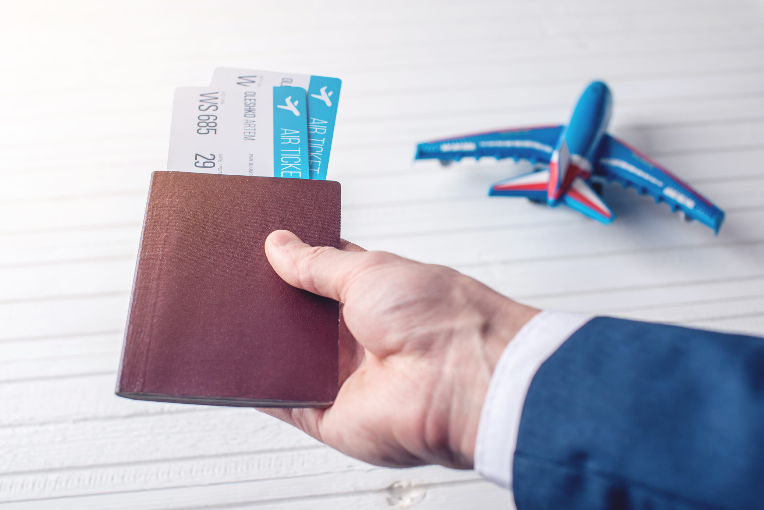 Hand Holding Passport and Flight Tickets